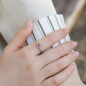 Infinity knot rainbow zircon ring in gold-plated silver finish worn on finger