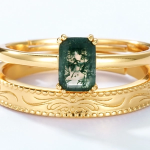 Close-up of moss agate stone and vintage gold-plated relief ring in a luxury stacked set