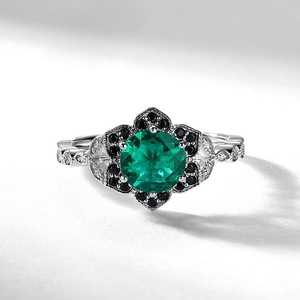 Anello a fiore in argento con smeraldo coltivato e alone di diamanti neri lucidi