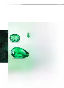 Detailed macro view of pear-cut emerald teardrop earrings with halo diamond accents