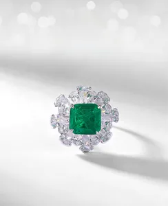 Détail macro d'une bague avec pierre verte taille émeraude et zircons clairs