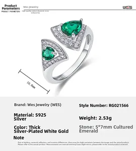 Macro detail of S925 silver bypass ring with pear-cut emeralds and tiny diamonds
