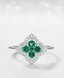 Gros plan sur bague émeraude de culture avec quatre pierres vertes et zircons blancs