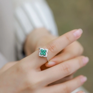 Bague trèfle à quatre feuilles en argent S925 avec émeraudes portée par un mannequin