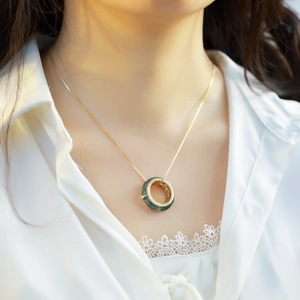 Collana in argento placcato oro con ciondolo in agata verde e dettagli intrecciati