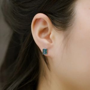 Close-up of S925 silver rectangle green moss agate stud earring worn by a model