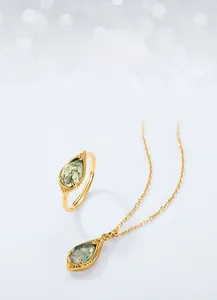 Detail of moss agate ring and pendant with natural green teardrop texture in gold plating