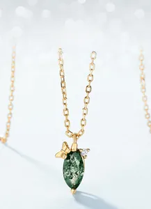 Detail of moss agate teardrop pendant with gold butterfly and sparkling crystal accent