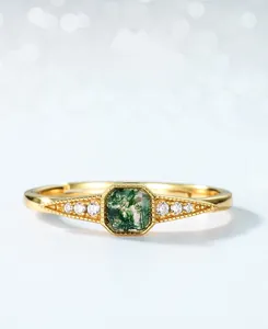 Macro detail of moss agate ring with side diamonds on a polished gold band