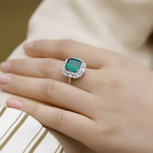 Macro d'une bague rétro en argent S925 avec émeraude et cristaux sur le doigt d'un mannequin