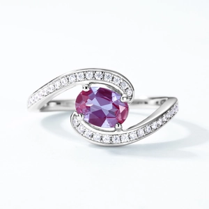 Macro detail of oval cut alexandrite gemstone on S925 silver ring with pave-set diamonds