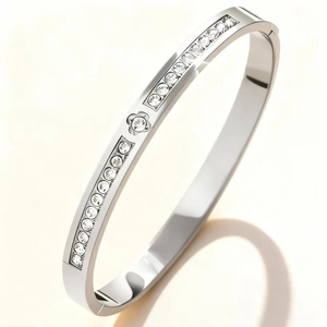 Detail of silver stainless steel bangle with clover design and zircon inlay details
