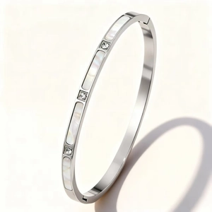 Detailed close-up of a silver stainless steel bangle with inlaid white mother-of-pearl