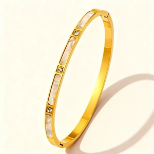 Close-up of gold plated stainless steel bangle featuring white shell inlay and crystals
