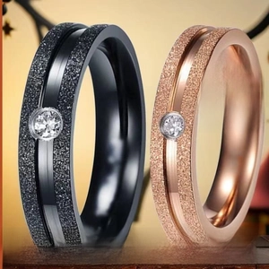 Dettaglio di anelli in acciaio inossidabile opaco con zircone in nero e oro rosa