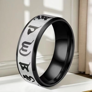 Close-up of dual-tone stainless steel ring with engraved Buddhist mantra symbols