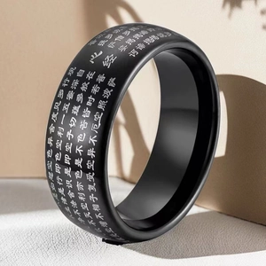Macro detail of black matte stainless steel ring with engraved Buddhist Heart Sutra