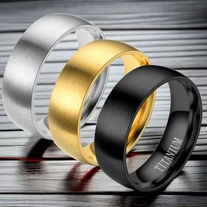 Macro shot of titanium steel rings in gold, silver, and black with brushed texture