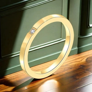 Detailed close-up of a gold-plated minimalist ring with a single inset diamond on wood