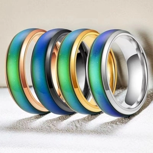 Close-up of five thermochromic mood rings in varied finishes like black and rose gold