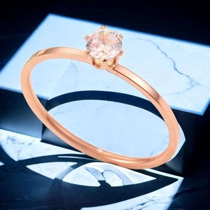 Gros plan d'une bague en or rose avec un zircon scintillant serti de six griffes