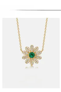 Détail du pendentif fleur dorée avec zircons blancs et pierre précieuse verte centrale