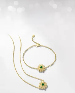 Macro d'un ensemble de bijoux marguerite doré avec émeraude de culture et zircons