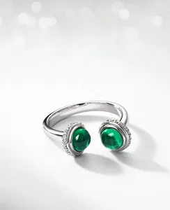 Macro detail of silver adjustable ring featuring two green lab-grown emerald gemstones