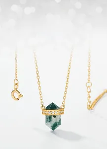 Detailed view of moss agate hexagonal pendant with gold frame and pavé small crystals