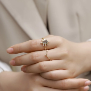 Close-up of moss agate ring set with hexagonal stone and V-shaped band on hand