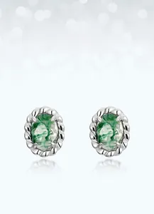 Macro detail of moss agate earrings with twisted silver rope border and green mineral inclusions