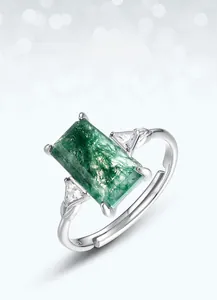 Macro view of rectangular green moss agate ring with side triangle stones and open band