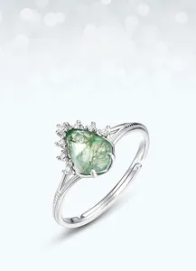 Gros plan sur l'agate mousse poire dans une bague en argent S925 avec petits diamants