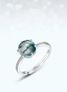 Detail of s925 silver six-prong setting with green moss agate on a textured open ring