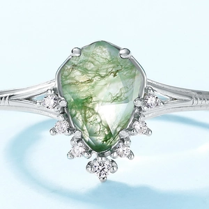 Bague en argent avec agate mousse taille cerf-volant et couronne de diamants sur fond bleu