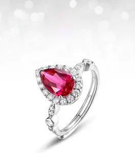 Macro view of pear-cut lab ruby ring with halo diamonds and marquise accents