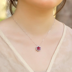 Collana in argento S925 con ciondolo a petalo di rubino indossata da modella con top a V