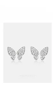 Macro shot of silver butterfly stud earrings with marquise red gems and diamond pavé wings