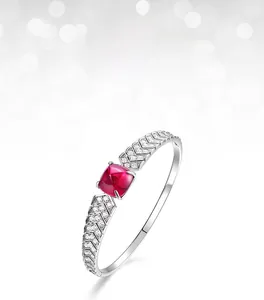 Close-up of a silver cuff bracelet featuring a sugar-loaf cut ruby and pavé diamonds