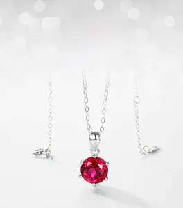 Detail of a classic six-prong setting necklace featuring a round red lab-grown ruby stone