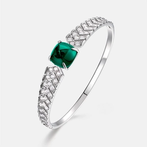 Detail of luxury S925 silver bangle with emerald gemstone and V-shaped pave diamond inlay