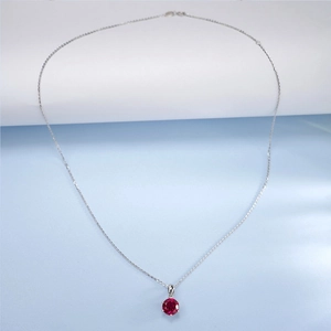 Macro shot of 925 sterling silver necklace with a six-prong set red lab ruby pendant