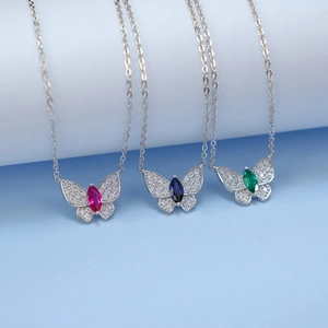S925 silver butterfly necklaces with pink, blue and green gemstones on blue background