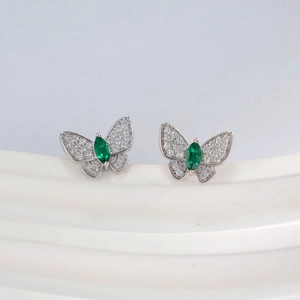 Detail of silver butterfly stud earrings with marquise green gems and pave white crystals