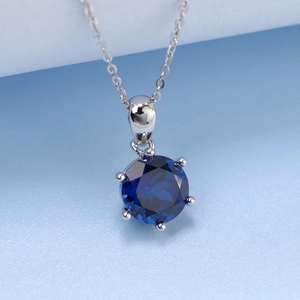 Macro shot of a brilliant blue gemstone necklace featuring a classic six-prong silver setting