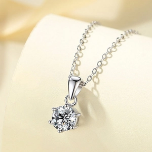 Macro shot of silver S925 necklace featuring a six-prong set round red gemstone pendant