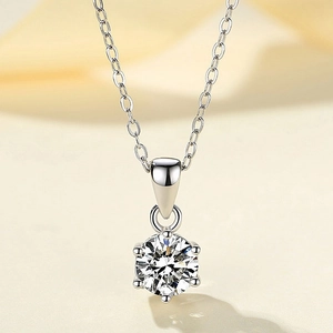 Macro shot of 925 sterling silver six-prong necklace with round cut sparkling ruby gemstone