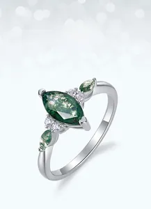 Macro shot of marquise cut moss agate ring with polished silver band and zircon accents