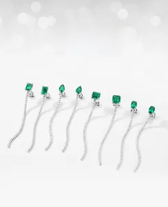 Vue détaillée de boucles d'oreilles en argent et émeraude avec design de pompons longs