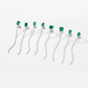 Gros plan de boucles d'oreilles émeraude en quatre formes avec chaînes argentées